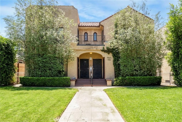 1732 W 48th St, Los Angeles, CA 90062 - mediterranean / spanish home featuring a balcony, stucco siding, a front yard, and french doors