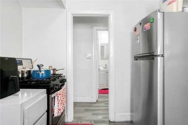 1732 W 48th St, Los Angeles, CA 90062 - kitchen with appliances with stainless steel finishes, wood finished floors, and baseboards