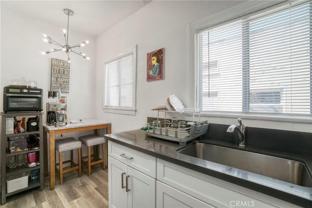 1732 W 48th St, Los Angeles, CA 90062 - kitchen featuring light wood-style floors, a chandelier, a sink, and plenty of natural light