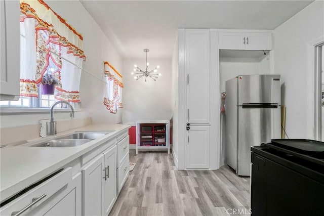 1732 W 48th St, Los Angeles, CA 90062 - kitchen featuring freestanding refrigerator, black stove, light countertops, white cabinetry, and a chandelier