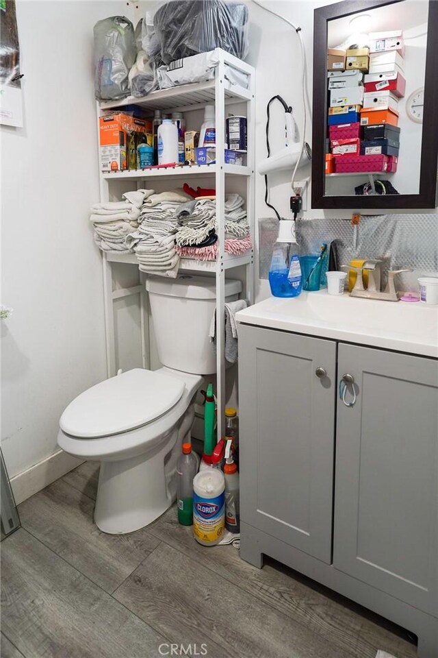 13672 Monroe St, Westminster, CA 92683 - bathroom with wood finished floors, toilet, vanity, and baseboards
