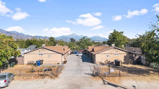 7771 Mckinley Ave, Highland, CA 92346 - view of front facade featuring concrete driveway, a fenced front yard, and a mountain view