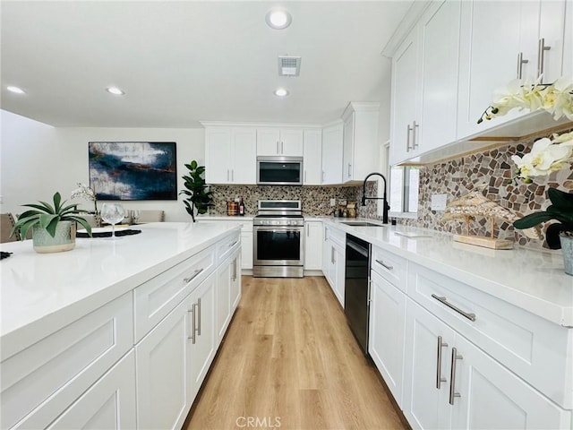 32942 Paseo Del Lucero, San Juan Capistrano, CA 92675 - kitchen with stainless steel appliances, backsplash, light wood-style flooring, white cabinets, and recessed lighting