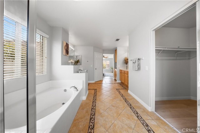 12337 Columbia Ln, Eastvale, CA 91752 - bathroom with vanity, a garden tub, inlaid floor details, and a walk in closet