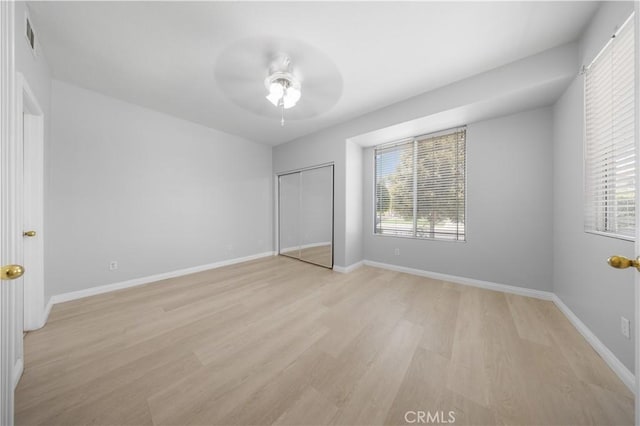 12337 Columbia Ln, Eastvale, CA 91752 - unfurnished bedroom featuring light wood-style flooring, multiple windows, a closet, and a ceiling fan
