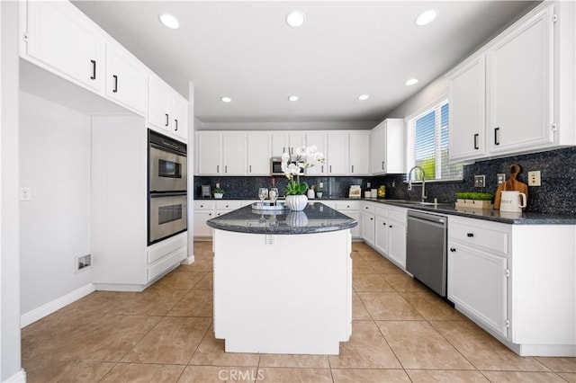 12337 Columbia Ln, Eastvale, CA 91752 - kitchen with appliances with stainless steel finishes, a center island, backsplash, white cabinets, and recessed lighting