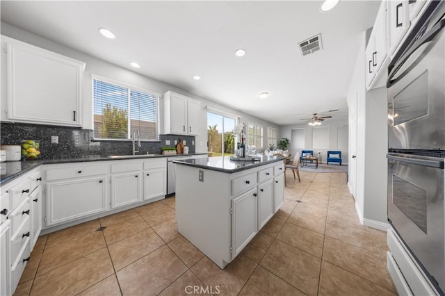 12337 Columbia Ln, Eastvale, CA 91752 - kitchen featuring a center island, stainless steel double oven, backsplash, white cabinets, and recessed lighting