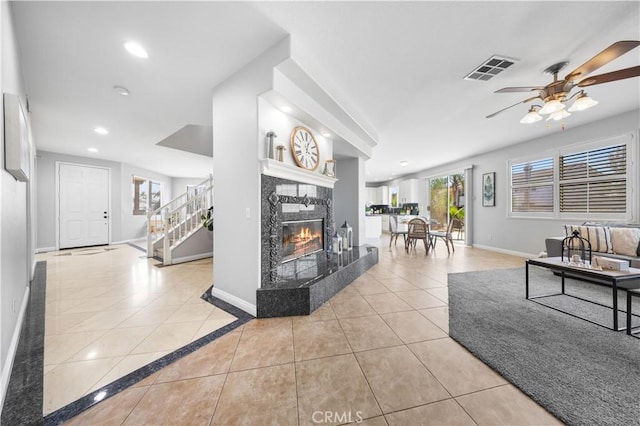 12337 Columbia Ln, Eastvale, CA 91752 - living room featuring stairs, light tile patterned floors, a ceiling fan, a tile fireplace, and recessed lighting