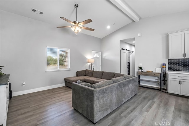 22375 Fairmead Cir, Chowchilla, CA 93610 - living room with a barn door, ceiling fan, beam ceiling, wood finished floors, and high vaulted ceiling