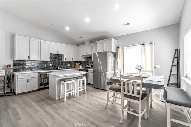 22375 Fairmead Cir, Chowchilla, CA 93610 - kitchen with appliances with stainless steel finishes, decorative backsplash, under cabinet range hood, light countertops, and vaulted ceiling