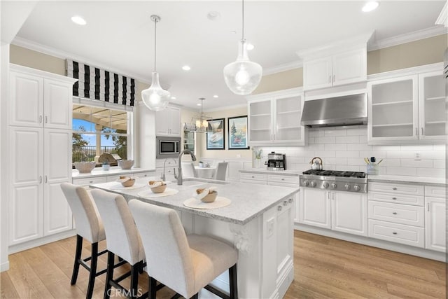 37 Craftsbury Pl, Ladera Ranch, CA 92694 - kitchen with stainless steel appliances, ornamental molding, extractor fan, white cabinets, and recessed lighting