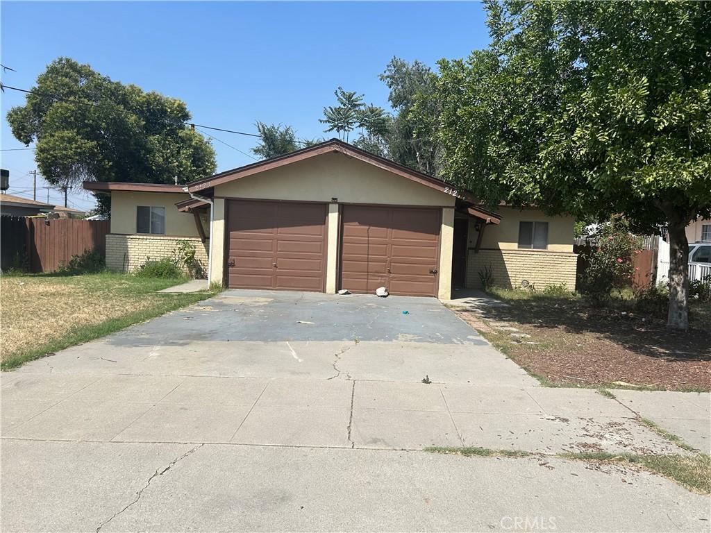 2121 Down St, Riverside, CA 92507 - view of front of home with stucco siding, driveway, and a garage