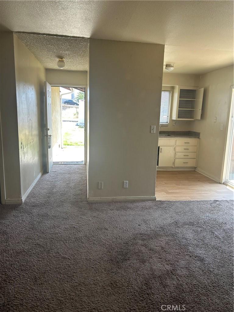 2121 Down St, Riverside, CA 92507 - unfurnished living room with light carpet, a textured ceiling, and baseboards