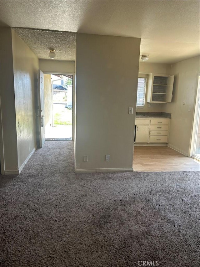 2121 Down St, Riverside, CA 92507 - unfurnished living room with light carpet, a textured ceiling, and baseboards