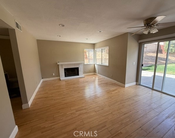 27745 Desert Pl, Castaic, CA 91384 - unfurnished living room featuring plenty of natural light, ceiling fan, light wood-style flooring, a fireplace, and recessed lighting