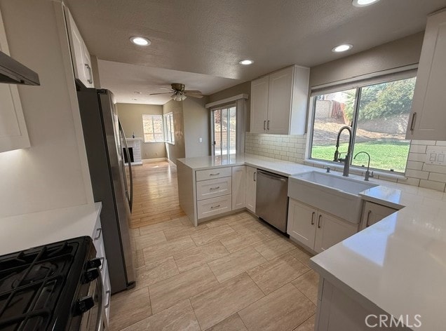 27745 Desert Pl, Castaic, CA 91384 - kitchen with appliances with stainless steel finishes, recessed lighting, backsplash, ceiling fan, and white cabinets