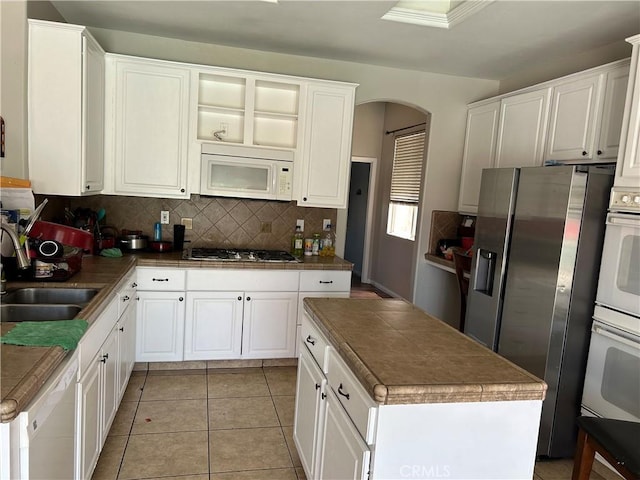 5825 Sky Lakes Ave, Bakersfield, CA 93313 - kitchen featuring white appliances, arched walkways, backsplash, and white cabinetry