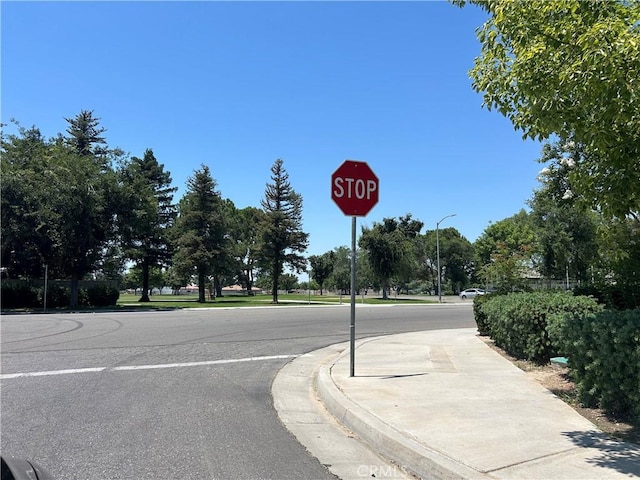 5825 Sky Lakes Ave, Bakersfield, CA 93313 - view of asphalt street featuring traffic signs, curbs, sidewalks, and street lights