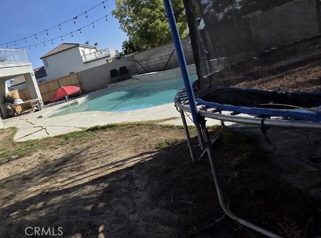 5825 Sky Lakes Ave, Bakersfield, CA 93313 - view of swimming pool featuring a fenced backyard and a trampoline