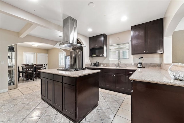 921 N Brand Blvd, San Fernando, CA 91340 - kitchen with arched walkways, island range hood, light tile patterned flooring, dark brown cabinetry, and recessed lighting