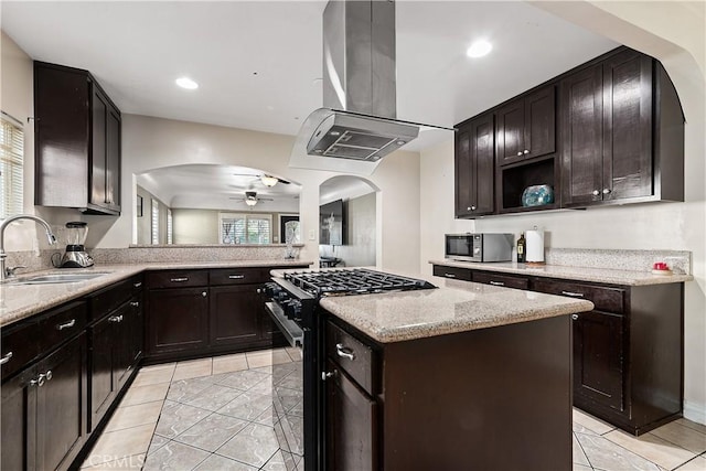 921 N Brand Blvd, San Fernando, CA 91340 - kitchen with black gas stove, island range hood, stainless steel microwave, arched walkways, and recessed lighting