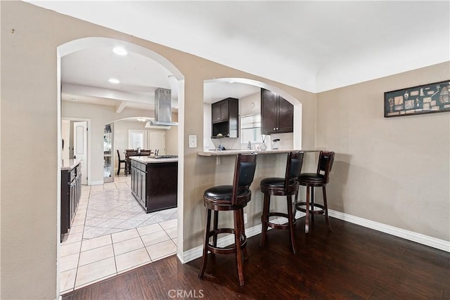 921 N Brand Blvd, San Fernando, CA 91340 - kitchen featuring island range hood, a kitchen bar, light countertops, light wood-type flooring, and recessed lighting