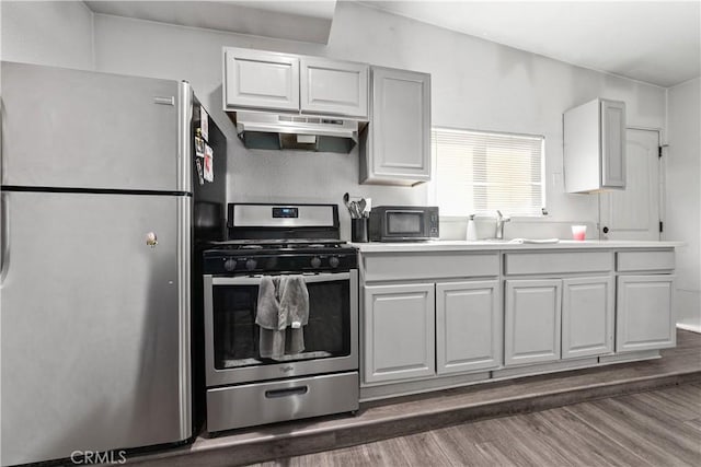 921 N Brand Blvd, San Fernando, CA 91340 - kitchen featuring appliances with stainless steel finishes, under cabinet range hood, wood finished floors, and light countertops
