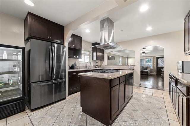 921 N Brand Blvd, San Fernando, CA 91340 - kitchen with stainless steel appliances, arched walkways, island range hood, dark brown cabinets, and recessed lighting