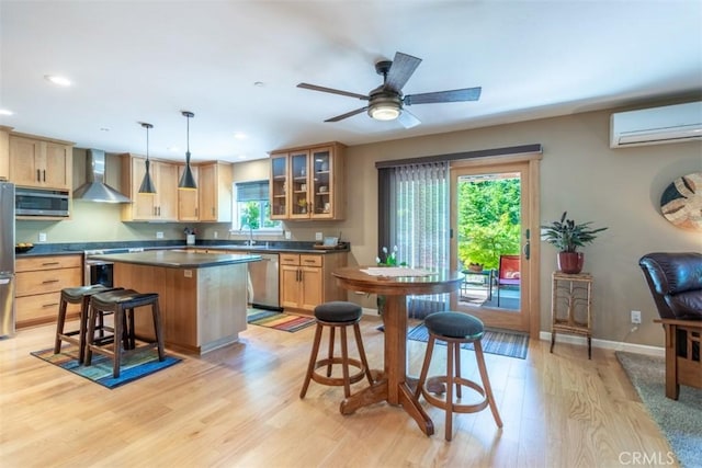 9116 Rocky Rd, Weed, CA 96094 - kitchen with appliances with stainless steel finishes, wall chimney range hood, a wall mounted air conditioner, light wood-style flooring, and dark countertops