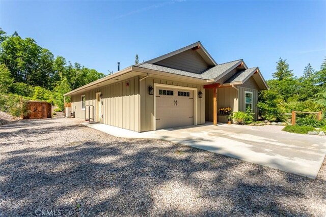 9116 Rocky Rd, Weed, CA 96094 - view of side of home with driveway, board and batten siding, an attached garage, and a shingled roof