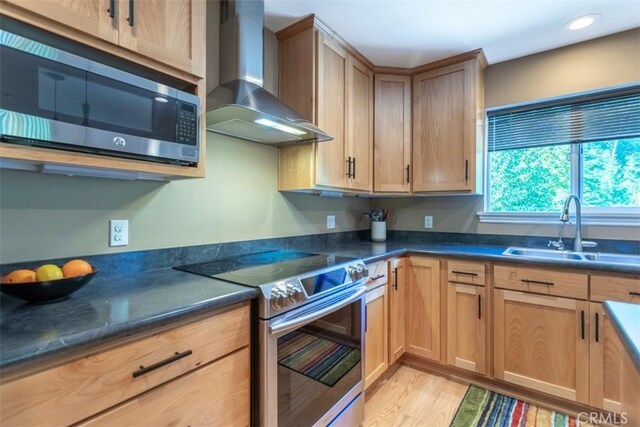 9116 Rocky Rd, Weed, CA 96094 - kitchen featuring wall chimney exhaust hood, appliances with stainless steel finishes, a sink, light wood-style floors, and recessed lighting