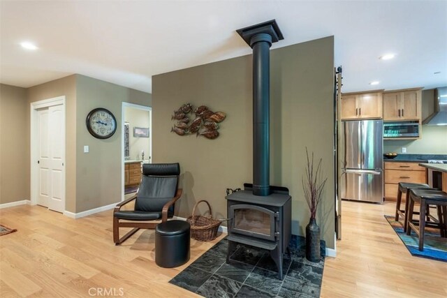 9116 Rocky Rd, Weed, CA 96094 - living area with a wood stove, light wood finished floors, baseboards, and recessed lighting