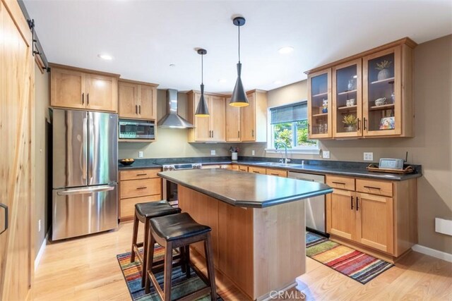 9116 Rocky Rd, Weed, CA 96094 - kitchen featuring appliances with stainless steel finishes, wall chimney range hood, dark countertops, a sink, and light wood finished floors