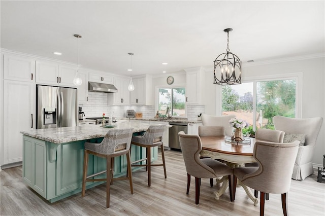 27705 Calle Valdes, Mission Viejo, CA 92692 - kitchen featuring appliances with stainless steel finishes, under cabinet range hood, healthy amount of natural light, tasteful backsplash, and crown molding