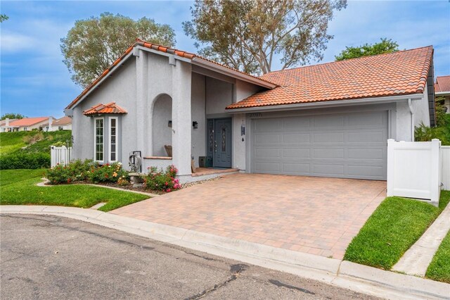 27705 Calle Valdes, Mission Viejo, CA 92692 - mediterranean / spanish-style home featuring stucco siding, an attached garage, decorative driveway, and a tiled roof