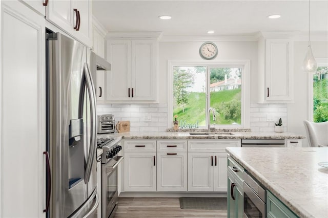 27705 Calle Valdes, Mission Viejo, CA 92692 - kitchen with stainless steel appliances, white cabinets, decorative backsplash, light wood-style floors, and ornamental molding