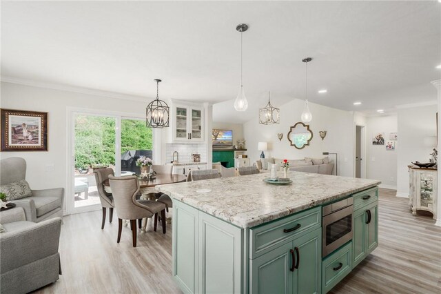27705 Calle Valdes, Mission Viejo, CA 92692 - kitchen with green cabinets, open floor plan, stainless steel microwave, light wood finished floors, and recessed lighting