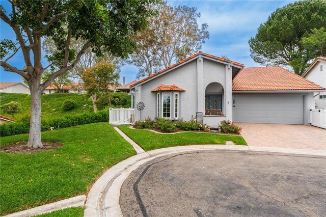 27705 Calle Valdes, Mission Viejo, CA 92692 - mediterranean / spanish house with a tile roof, decorative driveway, stucco siding, and an attached garage