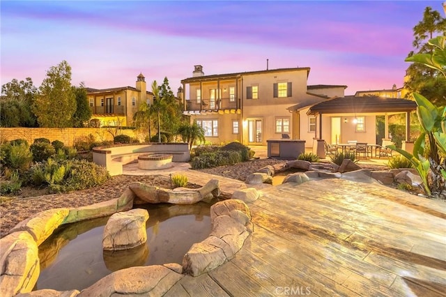 19599 Highland Terrace Dr, Walnut, CA 91789 - back of house at dusk featuring a hot tub, a balcony, a patio area, a gazebo, and outdoor dining space