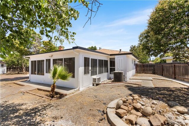 4561 N Price Ave, Fresno, CA 93726 - back of house with a sunroom, a fenced backyard, central AC unit, and a chimney