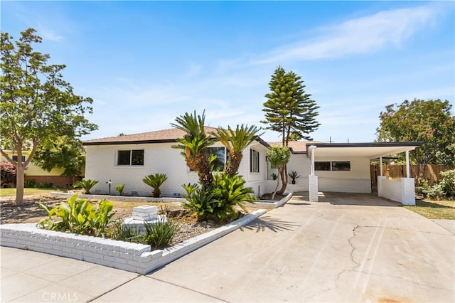 4561 N Price Ave, Fresno, CA 93726 - ranch-style home featuring concrete driveway, a carport, and brick siding