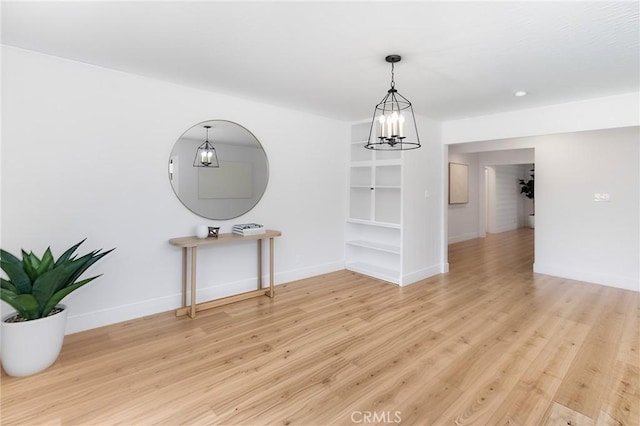 4561 N Price Ave, Fresno, CA 93726 - spare room featuring a chandelier, baseboards, light wood-style flooring, and built in features