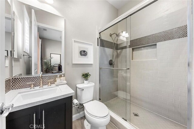 11 Goldenrod, Lake Forest, CA 92630 - bathroom featuring vanity, a stall shower, toilet, and backsplash