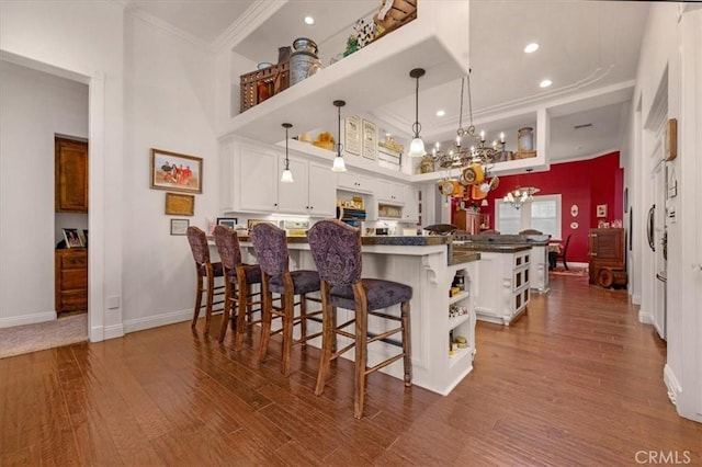 8401 Mayer Ave, Bakersfield, CA 93314 - kitchen with open shelves, ornamental molding, a chandelier, a kitchen bar, and white cabinets