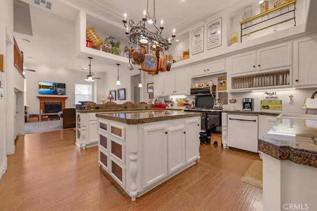 8401 Mayer Ave, Bakersfield, CA 93314 - kitchen with open shelves, a sink, a kitchen island, open floor plan, and a fireplace