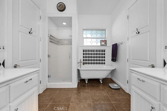 8401 Mayer Ave, Bakersfield, CA 93314 - bathroom with a shower stall, tile patterned floors, a freestanding tub, baseboards, and vanity