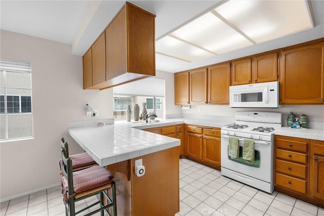 2300 Maple Ave Unit 138, Torrance, CA 90503 - kitchen featuring white appliances, a peninsula, plenty of natural light, and a breakfast bar area