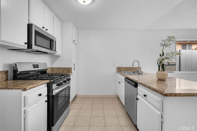 548 Bonita St, San Pedro, CA 90731 - kitchen with stainless steel appliances, a peninsula, white cabinets, stone countertops, and light tile patterned flooring