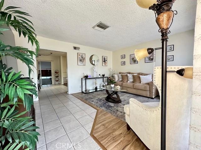 27441 Villa Ave, Highland, CA 92346 - living area with light tile patterned floors and a textured ceiling