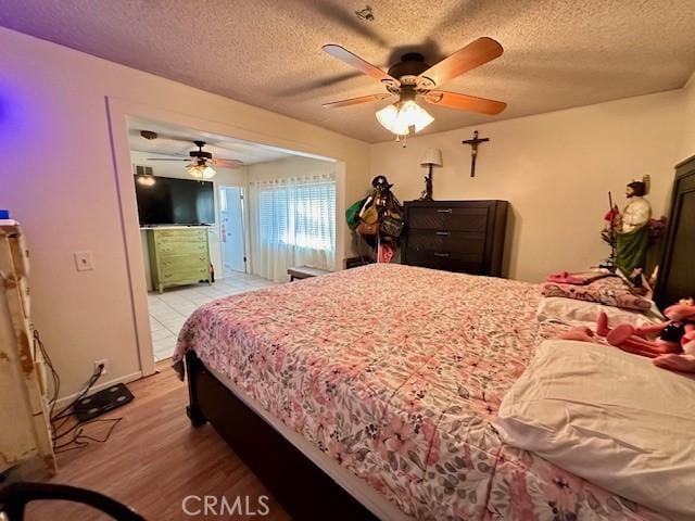 27441 Villa Ave, Highland, CA 92346 - bedroom with light wood-style floors, a textured ceiling, and ceiling fan